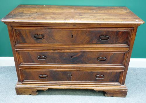 An early 18th century Italian walnut three drawer commode, on bracket feet, 126cm wide.
