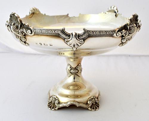 A silver pedestal centrepiece comport, of circular form decorated with a cast rim, the shaped circular base, raised on four scallop shell shaped feet,