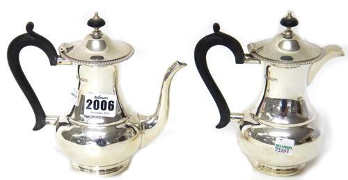 A silver two piece cafe au lait set, each piece of baluster form, with a decorated rim and having black fittings, Sheffield 1938, combined gross weigh