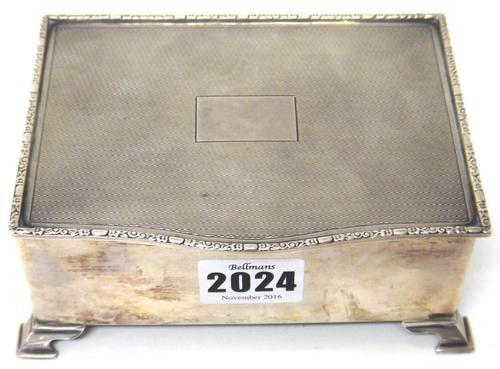 A silver rectangular table cigarette box, wooden lined within, the hinged lid with engine turned decoration and with a vacant rectangular cartouche, r