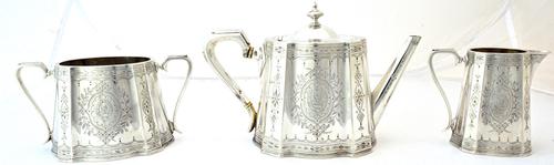 A Victorian silver three piece tea set, comprising; a teapot, a twin handled sugar bowl and a milk jug, each piece of tapering panelled form, with eng