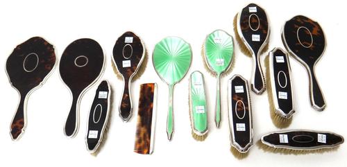 Silver mounted dressing table wares, comprising; three tortoiseshell hand mirrors, six tortoiseshell brushes, a green enamelled hand mirror, London 19
