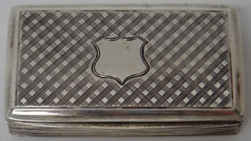 A Victorian silver rectangular hinge lidded snuff box, decorated with reeded sides and with a vacant shield shaped cartouche to the lid, on a cross ha