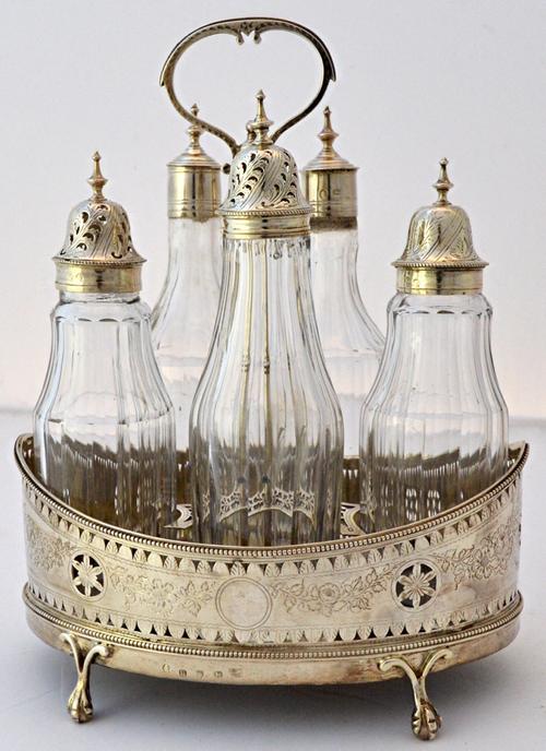 A George III five bottle silver cruet stand, of oval form with engraved and pierced decoration within beaded rims, fitted with a loop shaped handle, r