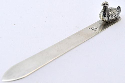 A Victorian silver letter opener by Sampson Mordan & Co, Chester 1908, the top end applied with a figure of a duck. Illustrated.