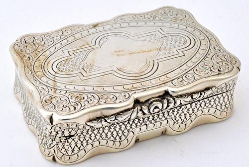 A Victorian silver shaped rectangular hinge lidded snuff box, with a floral moulded thumbpiece, otherwise with engraved decoration, Birmingham 1859, w