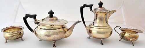 A silver three piece tea set, comprising; a teapot, a sugar bowl and a milk jug, each piece with shaped rims, Sheffield 1924 and a silver hot water ju