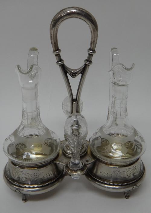 An Austrian oil and vinegar cruet frame, the stand with two circular bottle compartments, rings to take the stoppers and with a loop shaped handle, ra