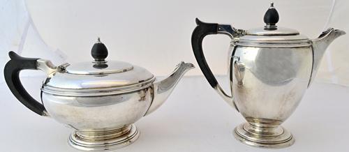 A silver four piece tea set, comprising; a tea pot, a hot water jug, a twin handled sugar bowl and a milk jug, each piece of circular form, the larger