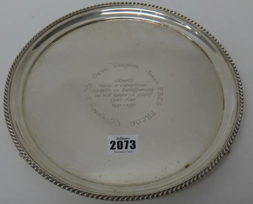 A silver salver, of shaped circular form, presentation inscribed in Welsh to the centre, within a gadrooned rim, raised on three feet, diameter 25cm,