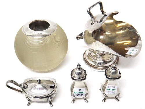 A silver three piece cruet set, comprising; a salt, a pepperette and a mustard pot, having a blue glass liner, Birmingham 1966, a silver mounted spher