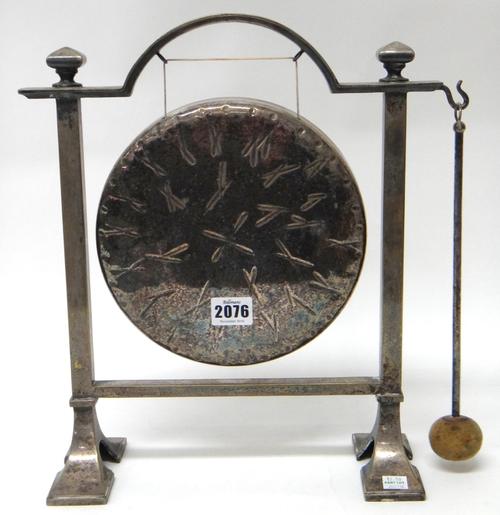 A plated dinner gong, with a stand and with a beater.