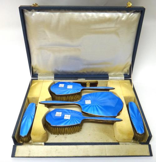 A lady's silver and blue enamel mounted five piece dressing set, comprising; a hand mirror, two hairbrushes and two clothes brushes, Birmingham 1941 a