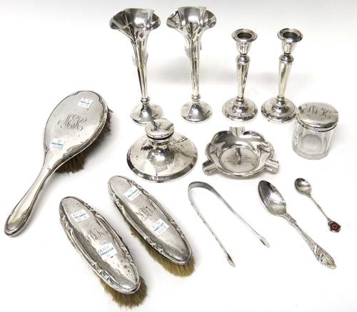 Silver and silver mounted wares, comprising; two similar bud vases, a hairbrush, two clothes brushes, a pair of small candlesticks (loaded), Birmingha