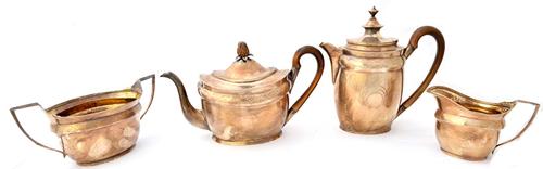 A silver composite four piece tea set, comprising; a George III teapot, the hinged lid with a pineapple finial and with a wooden handle, London 1803,