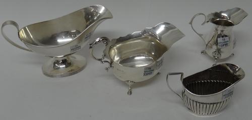 Silver, comprising; a sauceboat, decorated with reeded rims, Birmingham 1967, another sauceboat, Birmingham 1919, a cream jug, raised on three feet, B