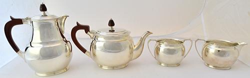 A silver four piece tea set, comprising; a teapot, a hot water jug, a twin handled sugar bowl and a milk jug, each piece of oval baluster form, the la