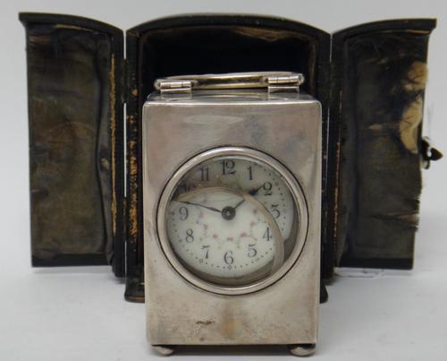 A silver rectangular cased carriage clock timepiece, the floral decorated enamelled dial with black Arabic numerals, the case fitted with a loop shape
