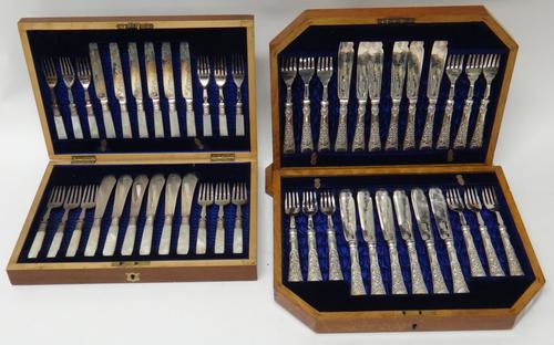 A set of twelve pairs of plated fish knives and forks, decorated with floral swags, with a fitted oak case and a set of six pairs of plated fruit kniv