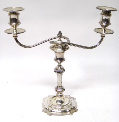 A silver twin light table candelabra, with scrolling fluted arms and on a shaped base, in the 18th century taste, Sheffield 1968, (loaded).