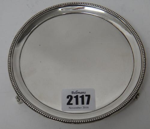 A George III silver small circular waiter, decorated with a beaded rim and raised on three beaded feet, London 1809, diameter 13cm, weight 143 gms.