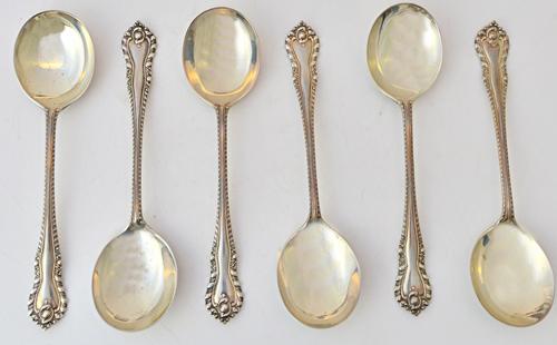 A set of six silver soup spoons, with cast decoration to the handles, by Walker & Hall, Sheffield 1914, weight 380 gms, cased. Illustrated.