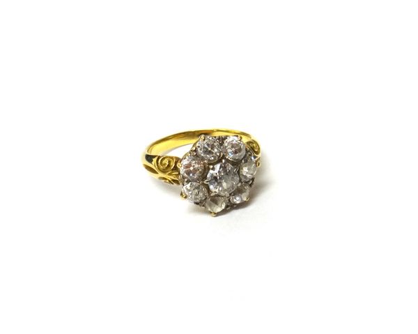 A gold and diamond set seven stone cluster ring, claw set with the principal cushion shaped diamond at the centre, in a surround of seven smaller cush