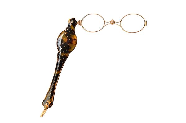 A pair of gold mounted tortoiseshell sprung folding lorgnettes, circa 1900, the handle decorated with stars and fitted with oval lenses. Illustrated.