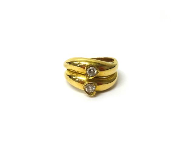 A gold and diamond set ring, in a twin twistover design, mounted with two circular cut diamonds, within heart shaped surrounds, ring size L.