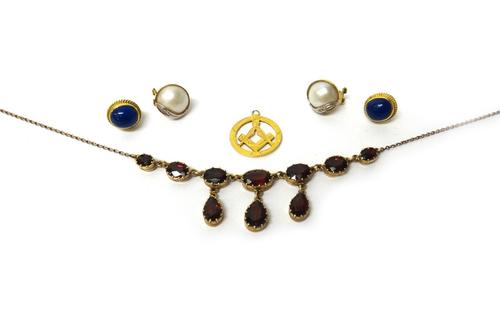 A 9ct gold and garnet set necklace, mounted with a row of seven graduated oval cut garnets and with three pear shaped garnet drops to the front, a pai