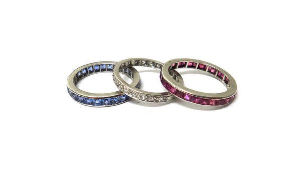 A diamond set full eternity ring, mounted with circular cut diamonds, ring size P and a half, a ruby set full eternity ring, mounted with calibre cut