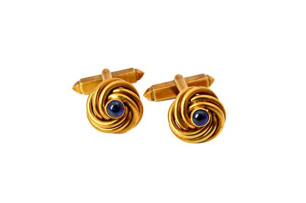 A Kutchinsky pair of 18ct gold and cabochon sapphire set dress cufflinks, the fronts of each in an interwoven design, centred by a cabochon sapphire,