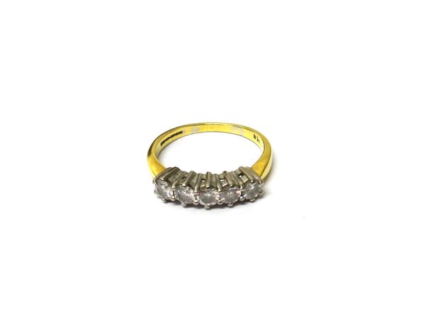 A gold and diamond set five stone ring, claw set with a row of circular cut diamonds, ring size K and a half, with a case.