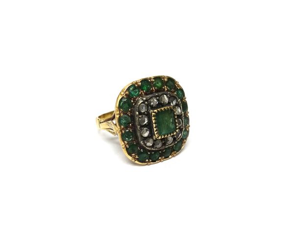 A gold, emerald and diamond cluster ring, mounted with the rectangular cut emerald at the centre, in a surround of rose cut diamonds and with a border