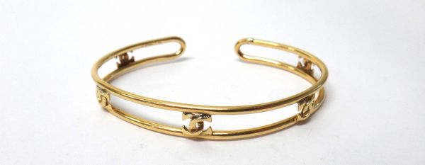 A Cartier gold bangle, with five interlocking 'C' motifs, detailed Cartier 18 K, weight 12.2 gms.