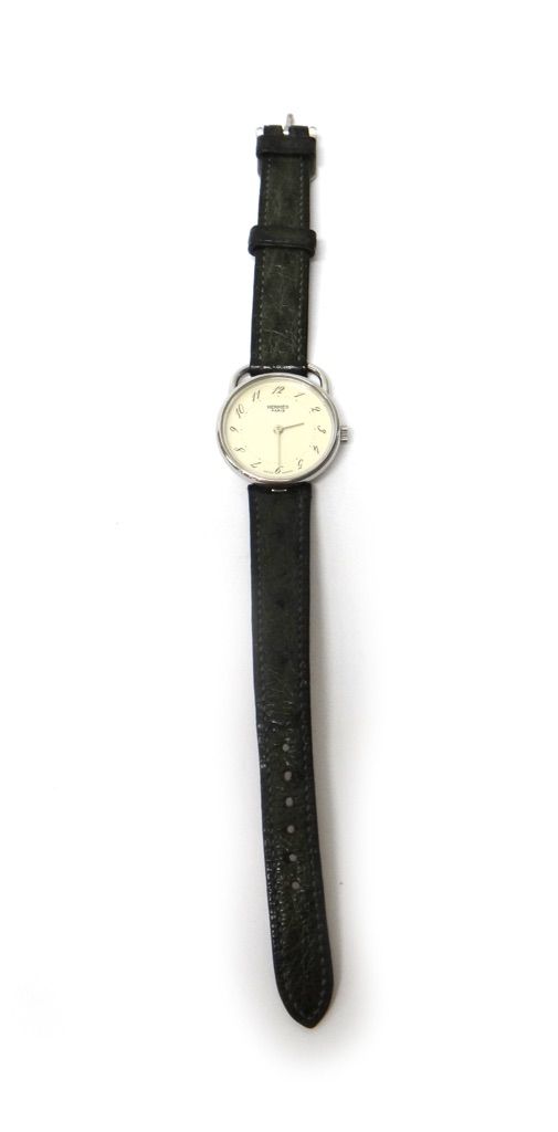 A Hermes Quartz lady's steel circular cased wristwatch, the signed circular dial with black Arabic numerals, on a leather strap, circa 1985.