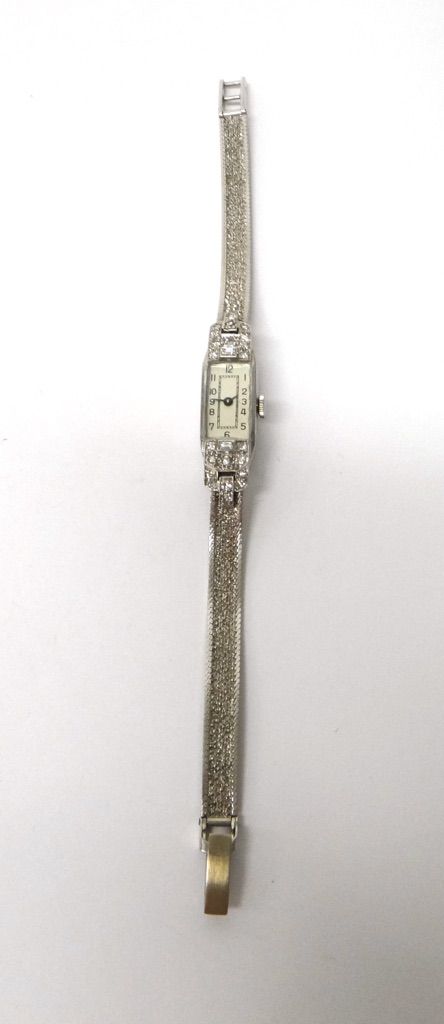 A lady's platinum cased and diamond set dress wristwatch, with an unsigned jewelled Swiss movement, the case terminals mounted with baguette and circu