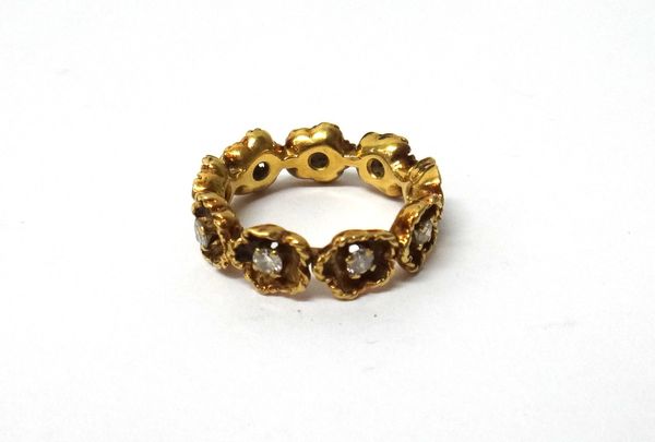 A gold and diamond set full eternity ring, designed as a row of flowerheads, each centred by a circular cut diamond, ring size K and a half, with a ca