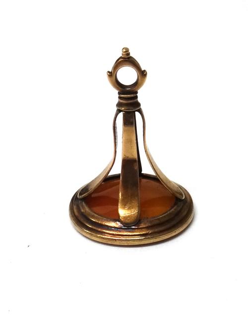 A gold mounted cornelian set fob seal, motto and cherub seal engraved, circa 1800.