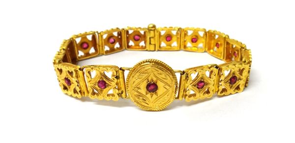 An Eastern gold and synthetic ruby set bracelet, the links in an engraved and pierced design and with a central circular panel, probably Indian, 1950'