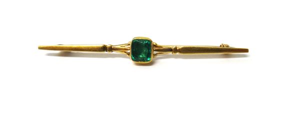 A gold and emerald set single stone bar brooch, mounted with a foil backed cushion shaped emerald, detailed 15 CT.