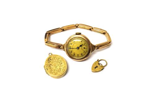 A lady's 9ct gold circular cased wristwatch, import mark London 1919, on an expanding bar link bracelet, detailed 9 C, a 9ct gold oval pendant locket,