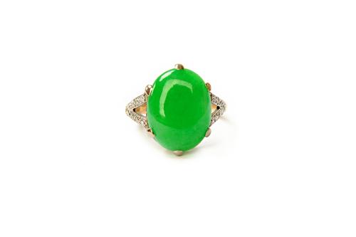 A gold and platinum, jade and diamond set ring, claw set with an oval cabochon jade, between diamond set 'V' shaped shoulders, detailed PLAT, ring siz