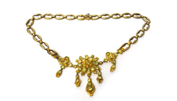 A gold and foil backed chrysolite necklace, the front formed as three principal panels supporting five pendant drops, on an associated composite link