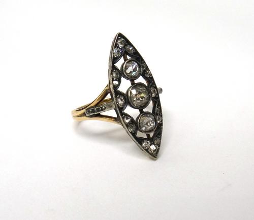 A Russian gold and silver set diamond ring, pierced in a marquise shaped design, mounted with the three principal cushion shaped diamonds to the centr