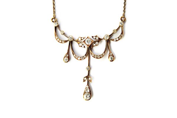 A Russian gold and diamond set necklace, the front with a foliate capped central drop, otherwise with pendant ribbon swags mounted with cushion shaped