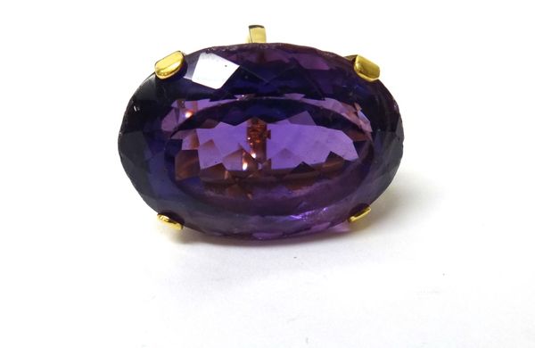 An 18ct gold ring, claw set with a large oval cut amethyst, London 1986, ring size K and a half.