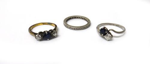 A platinum ring, claw set with a cushion shaped diamond and with a cushion shaped sapphire in a crossover design, a platinum and diamond set full eter