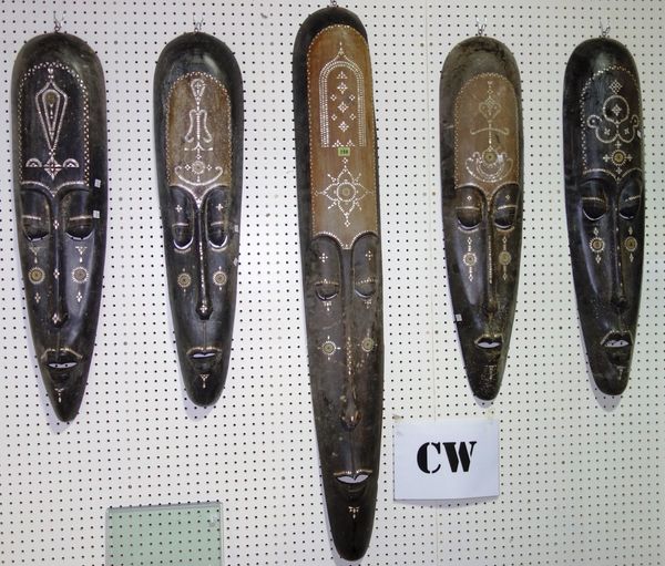 A group of five 20th century tribal masks with elongated faces and mother-of-pearl inlay. (5)  CW