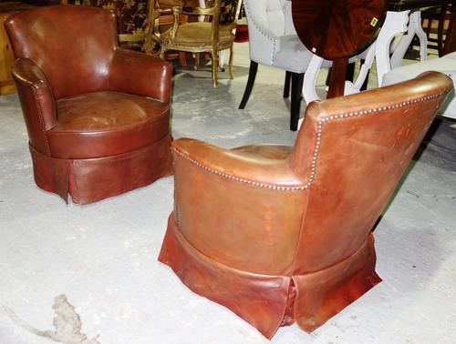 A pair of red leather upholstered tub back easy armchairs (2).  E4